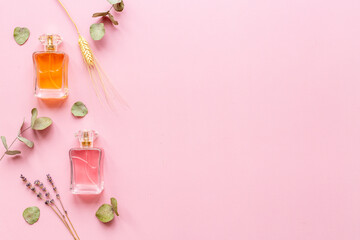 Perfume bottles flat lay with flowers and leaves, top view