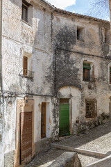 Fototapeta na wymiar Cobbled street and dilapidated facades of the old town of Bocairent, Valencia province, Spain