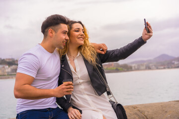Lifestyle of a couple sightseeing and enjoying the holidays. Taking a selfie photo with the mobile phone