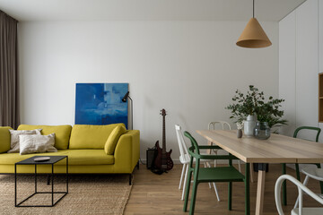 Modern living room with yellow sofa and dining table