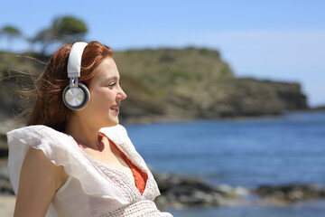 Woman in bikini listening to music enjoying on the beach