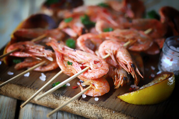 Grilled shrimp on sticks. Juicy BBQ shrimp with spices and lemon.