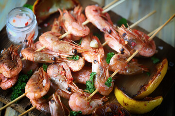 Grilled shrimp on sticks. Juicy BBQ shrimp with spices and lemon.