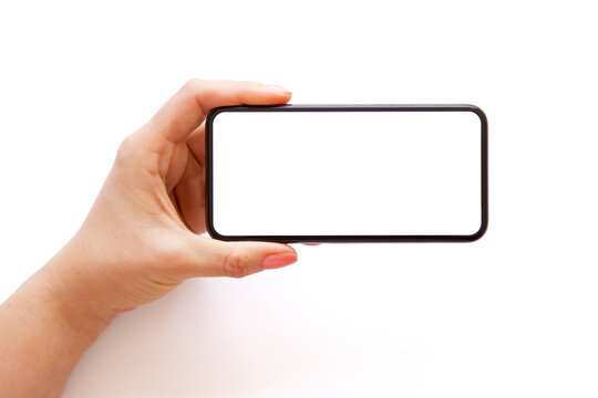 Mobile phone with empty white screen held horizontally in hand, isolated on white background