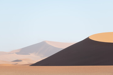 Fototapeta na wymiar Orange sand dunes and clear sky in Namib desert