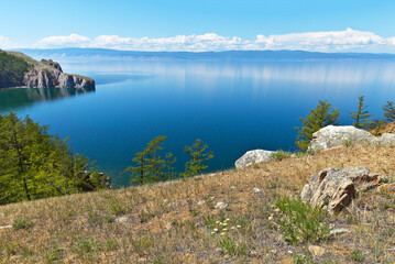 Naklejka na ściany i meble Baikal Lake. A calm landscape of the coast of Olkhon Island on a sunny summer day. View on Small Sea Strait and Sagan-Hushun Rock. Natural background. Summer vacation and travel