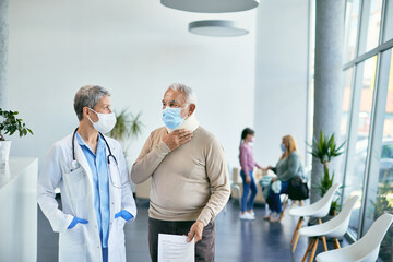 Obraz premium Senior patient with cervical collar complains about neck pain while communicating with doctor at medical clinic.