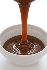 pouring homemade caramel sauce into bowl