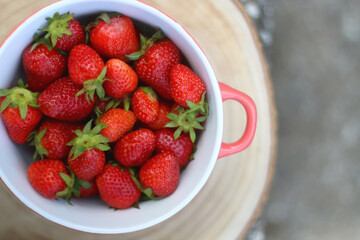Bowl of fresh strawberries on a table. Top view.