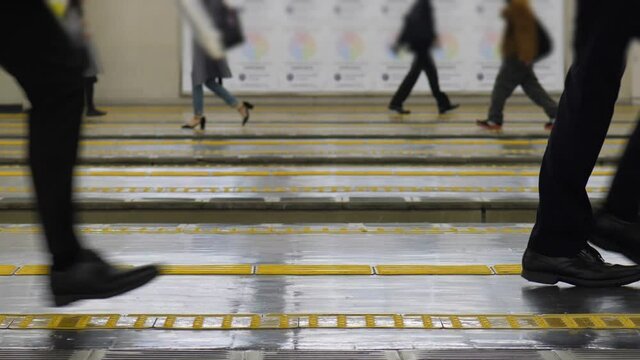 Commuters quickly walk and run, try to catch train. Slow motion shot, low half view of people legs and platform. Office workers hurry, want to go home at end of weekday
