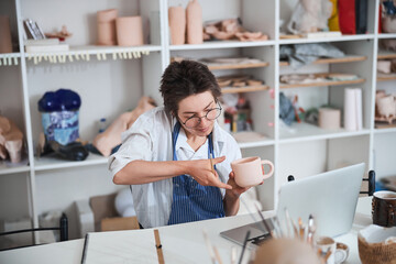 Pottery master measuring clay cup by eye