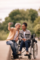 Lovely couple enjoying outside, using phone.