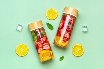 Strawberry infused water, cocktail, lemonade or tea. Summer iced cold drink with strawberry, lemon and lef of mint on green background. Flat lay. Top view.	