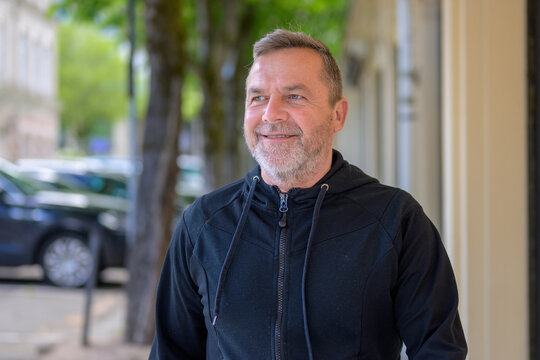 Middle-aged man chuckling to himself as he walks through town
