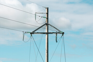 Fototapeta premium High voltage transmission lines over cloudy sky background