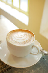 a cup of late coffee with flower shape design on top at cafe 