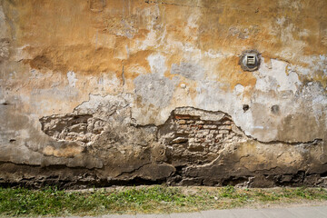 Old yellow plaster and brick wall