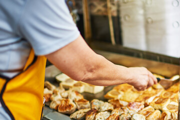 Woman hand reaching for a deep fried spring roll at food truck. Close up of food truck salesman serving street to customer. Asian street food , catering service.