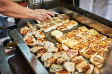 Deep fried spring roll sold outdoors at local market place, shallow depth of field. Street cooking is a tradition and ubiquitous in Asia.
