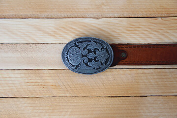 Leather cowboy belt on wooden background