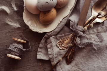 Flat lay of with vintage kitchenware kitchen utensils with Easter eggs on dark wooden background. Top view with copy space.