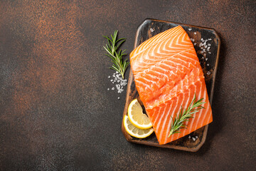 Fresh salmon fillet on wooden board and spices for cooking