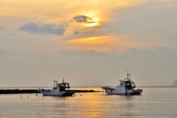 材木座海岸和賀江島に係留する漁船と沖に見えるウインドサーフィン