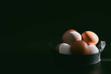 Chicken eggs in vintage tray on a black background. Organic, biological, bio products, bio ecology, healthy.