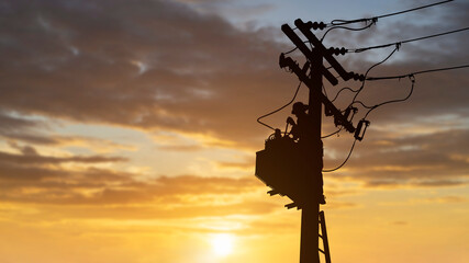 silhouette technicians work on high voltage transformers.
