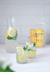 Fresh lemon lemonade with mint in bottle on kitchen table with ingredients. healthy nutrition diet...