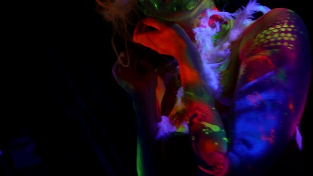 amazing neon figure of young lady in dark room, ultraviolet light, unusual body art