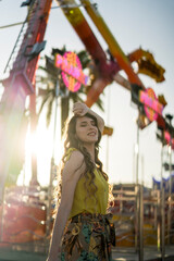 Mujer joven en vestido de verano divirtiéndose en el parque de atracciones