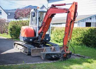 Image of a small excavator ready to dig in the garden.