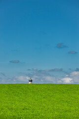 Zwiebelturm in Bayern hinter einem Hügel