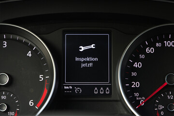 Fototapeta premium display in a car cockpit with german words Inspektion jetzt, translation service now
