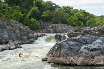 Ian Brown stand up paddle surfs challenging whitewater below Great Falls of the Potomac River, border of Maryland and Virginia