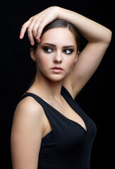 Beauty portrait of young woman. Brunette girl with evening female makeup and black dress