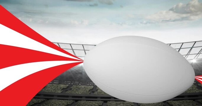 Animation of rugby ball with red and white trails on sports stadium background