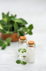 Spa and wellness setting with sea salt, oil essence, jasmin flowers and towels on wooden background. Relax and treatment therapy.