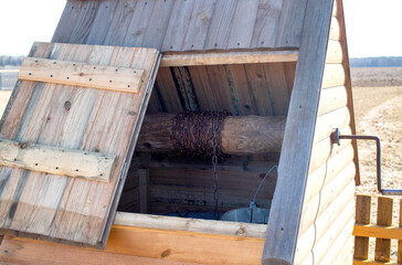 Beautiful and modern wooden well with water in a village in nature, background