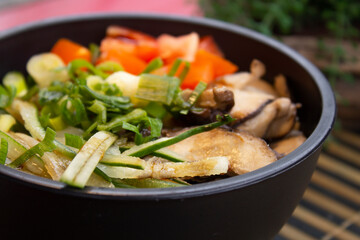 A closeup photo of poke with tomato, slices of shiitake and chives. 