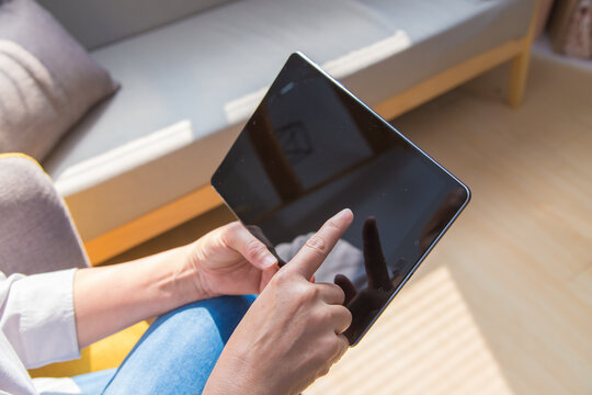 Closeup Of Senior Woman's Hand Using Tablet At Home.