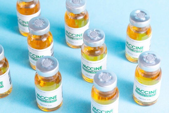 pattern from a vial with a coronavirus vaccine on a blue background. Many vials, vaccine side effects, macro