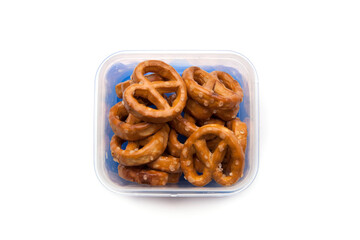 School lunch box snack for kids over white background. Back to school. Healthy and fun snack option for parents. Bow with pretzels.