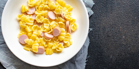 pasta sausages, cucumber salad vegetables, conchiglie menu on the table healthy food children's menu meal snack copy space food background rustic. top view