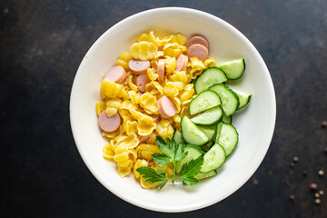 pasta sausages, cucumber salad vegetables, conchiglie menu on the table healthy food children's menu meal snack copy space food background rustic. top view