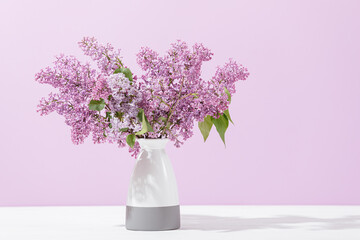 Bouquet of blooming lilacs in vase standing