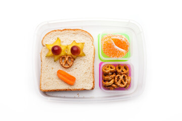 School lunch box snacks for kids over white background. Back to school. Healthy and fun snacks option for parents. Cute food art creative concepts. Bows with fruits and vegetables and cute sandwich.