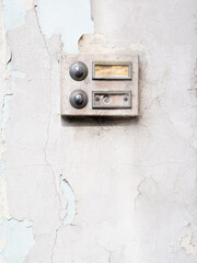 Fototapeta na wymiar Une vieille sonnette accrochée sur un mur de pierre à l'entrée d'une maison