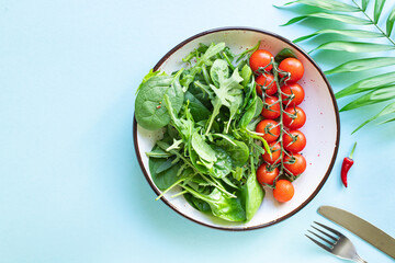 tomato salad cherry veggie green leaves fresh mix greens spinach, arugula, lettuce ingredient on the table healthy food meal copy space food background keto or paleo diet  